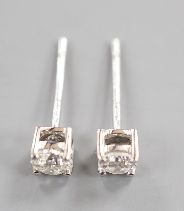 A modern pair of 9ct white gold and solitaire diamond set ear studs, gross 0.8 grams